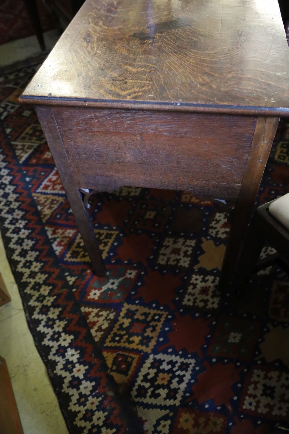 A George III oak low boy, with one long and two short drawers, with brass drop handles, on square section supports, width 79cm, depth 4